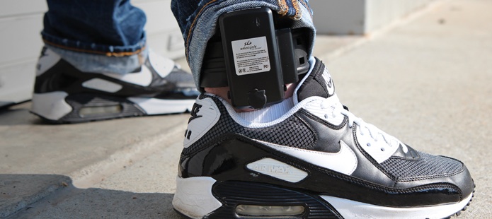 A Southern summer student models the new ankle monitors